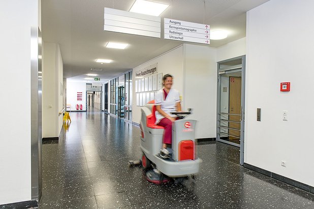Mitarbeiterin auf Aufsitzmaschine
