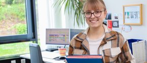Eine Mitarbeiterin aus der Verwaltung des Krankenhaus Martha-Maria St. Theresien nimmt eine Bewerbungsmappe entgegen.