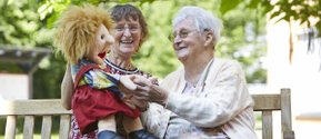 Eine Mitarbeiterin aus dem Seniorenzentrum Martha-Maria Nagold spielt mit einer Puppe mit einer dementen Frau