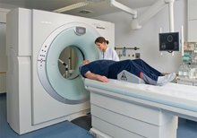 Patient liegt im CT-Gerät, betreut von medizinischem Personal.
