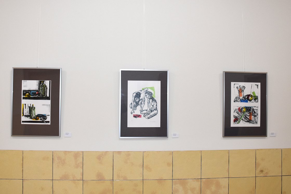 Drei gerahmte Kunstwerke an einer Galerie-Wand, modern und farbenfroh.