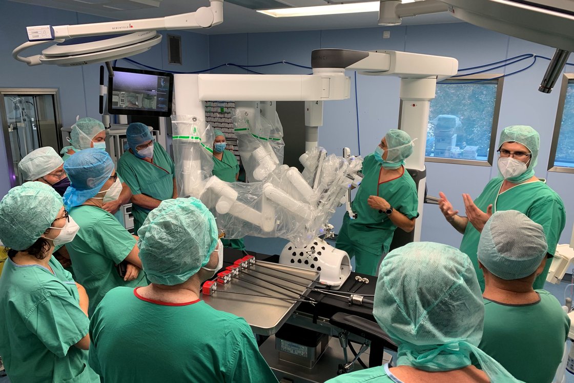 Ärzte in OP-Saal diskutieren über Einsatz eines chirurgischen Robotersystems.