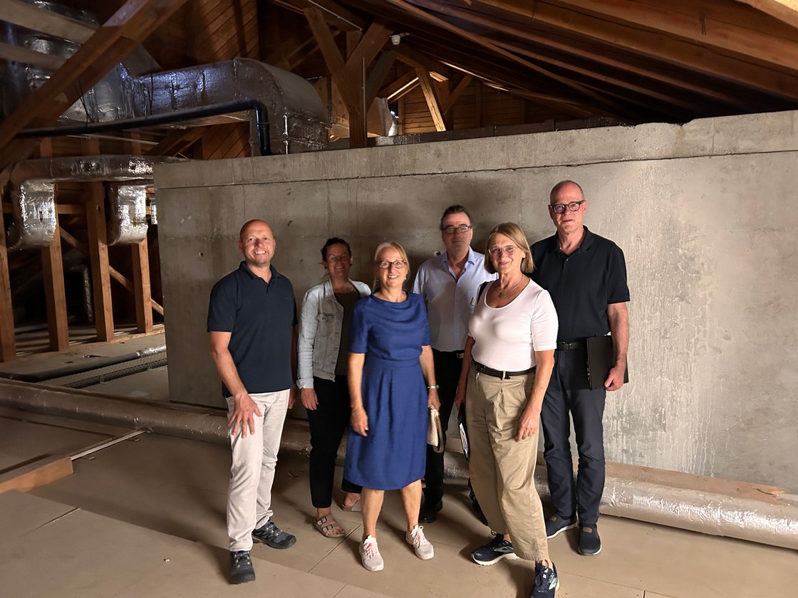 Gruppe von Personen im Dachboden des Seniorenzentrums zur Klimaanpassungsinspektion.
