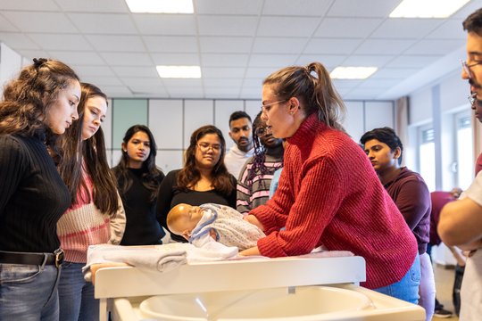 Unterrichtsstunde mit Pflegeauszubildenden und Lehrerin in der Berufsfachschule.