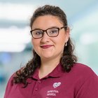 Mitarbeiterin in rotem Polohemd von Martha-Maria vor unscharfem Hintergrund.