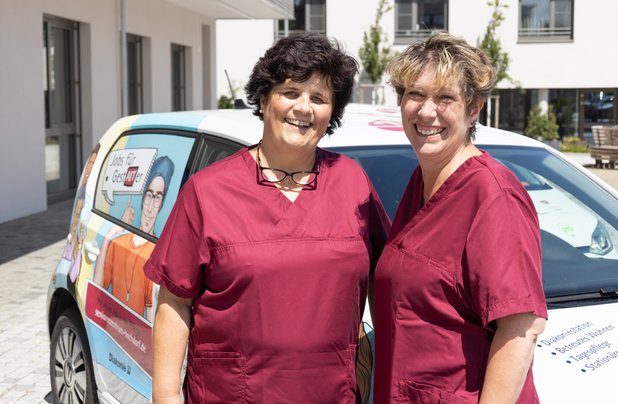 Zwei Pflegekräfte vor dem Auto der Diakoniestation im Seniorenzentrum Martha-Maria Lichtenstein-Honau