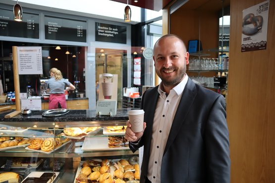 Kaufmännischer Leiter Markus Maier mit einem Recup-Becher im Bistro in Nürnberg