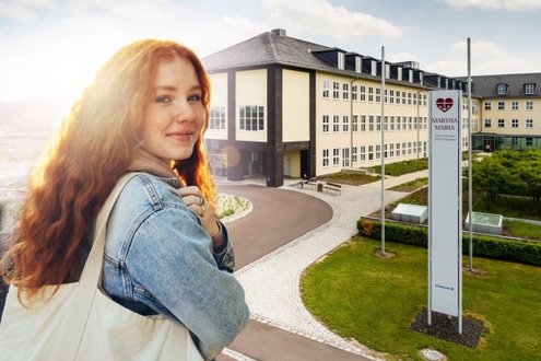 Frau vor Krankenhaus Martha-Maria Halle-Dölau, lächelnd, bei sonnigem Wetter.