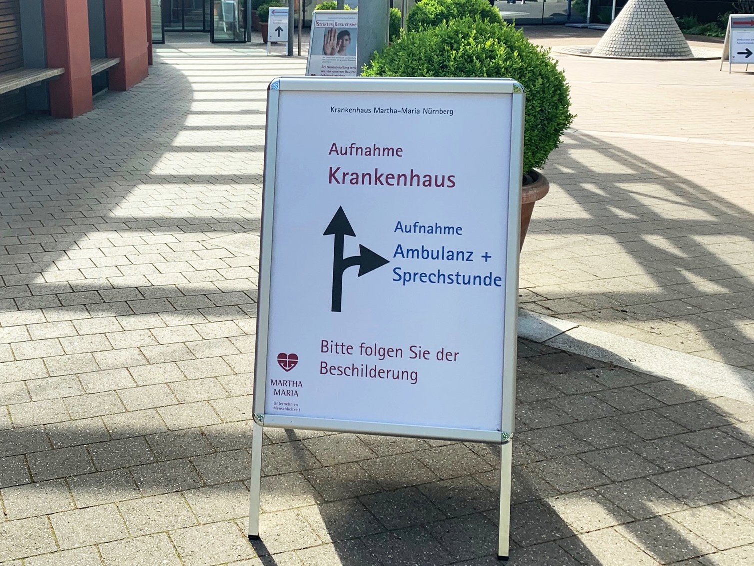 Eingang Krankenhaus Martha-Maria Nürnberg mit Hinweisschild zur Ambulanz.